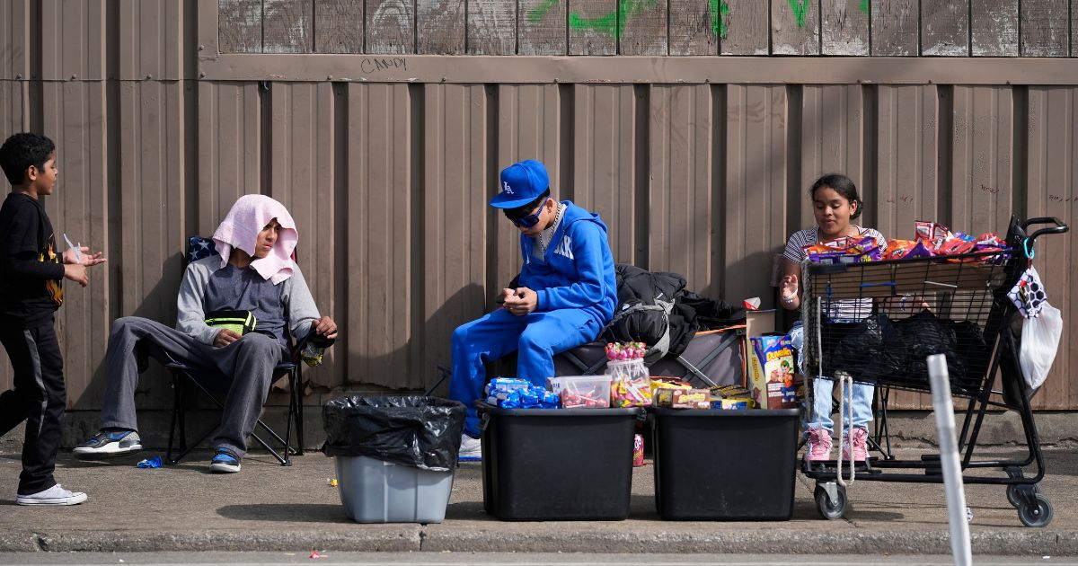 People sit outside a migrant shelter on March 13 in the Pilsen neighborhood of Chicago.