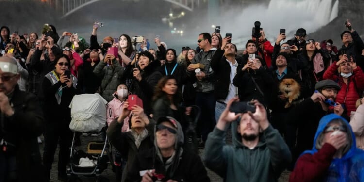 People gather to watch the total solar eclipse from Niagara Falls, Ontario, on Monday.