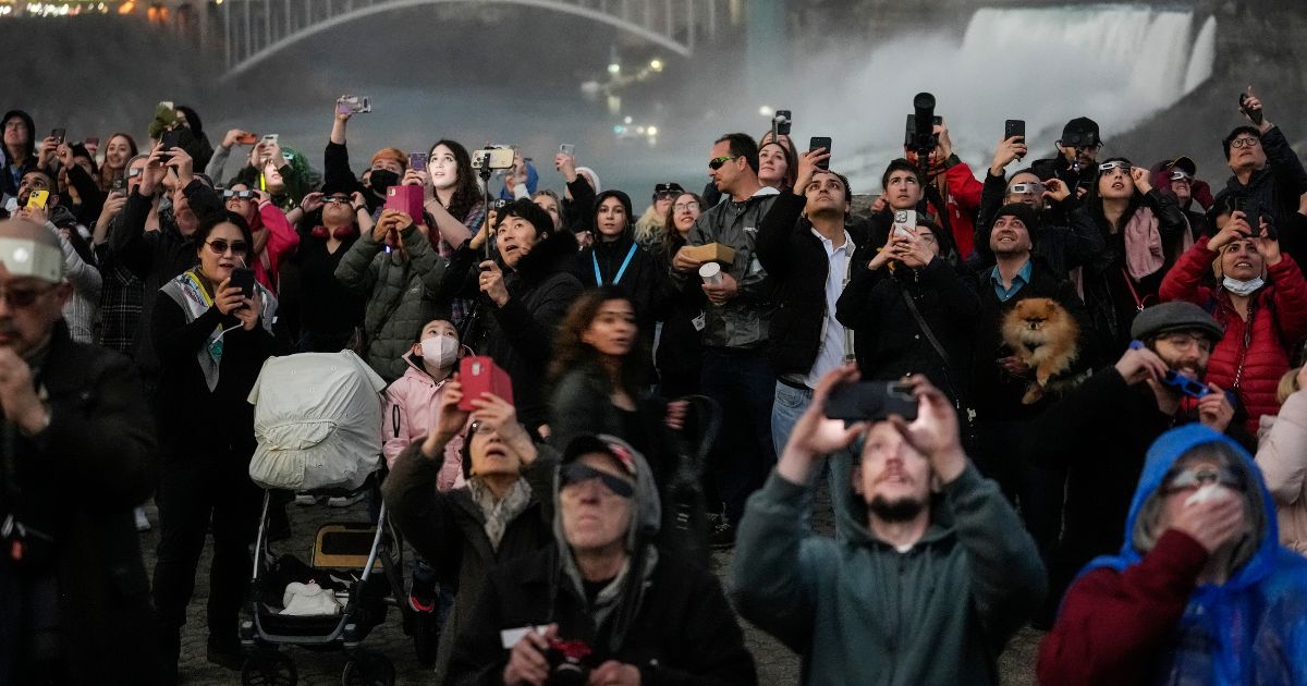 People gather to watch the total solar eclipse from Niagara Falls, Ontario, on Monday.