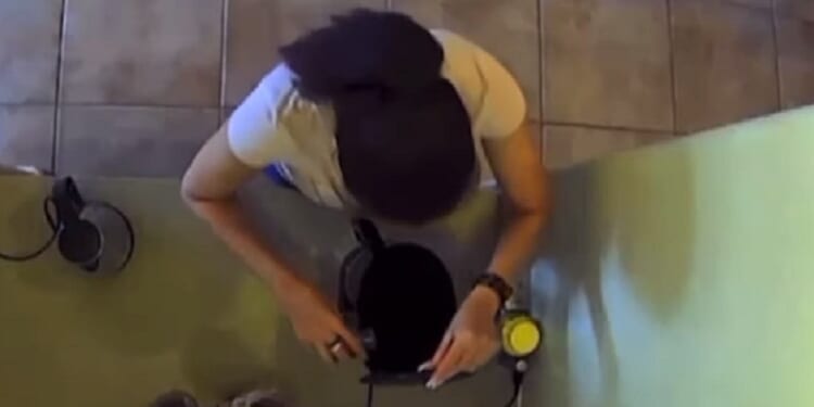 A woman pours bleach into her husband's coffee machine in a hidden-camera video.