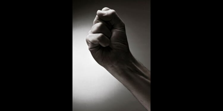 This photo shows someone's wrist and hand making a fist as a symbol of the desire to take revenge on an enemy.