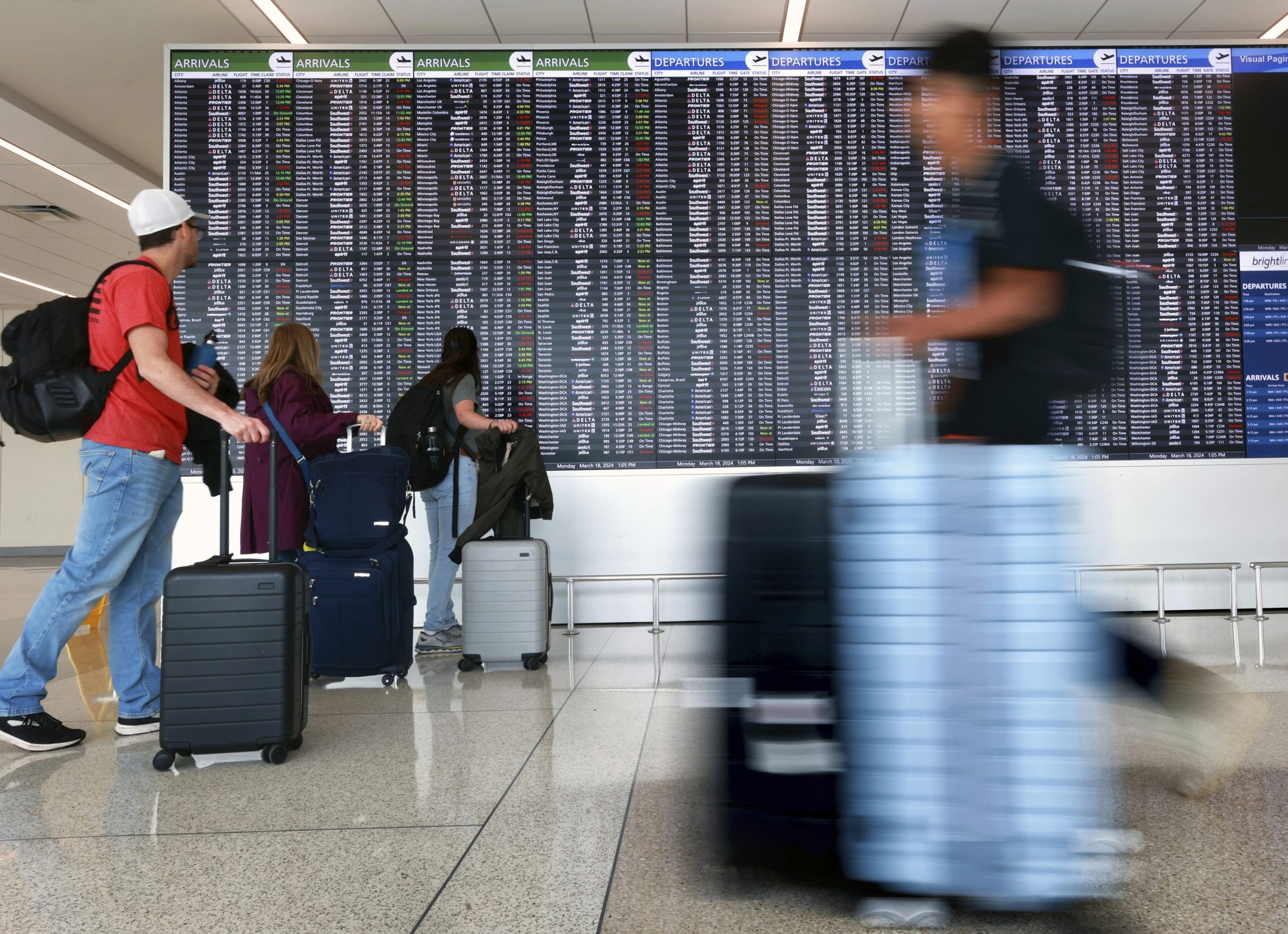 Passengers arrive at Terminal C at Orlando International Airport in Orlando, Florida on March 18.