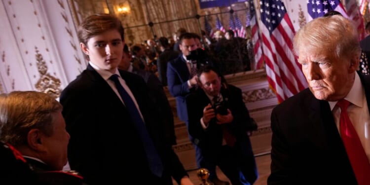 Barron Trump watches as his father greets people at Mar-a-Lago