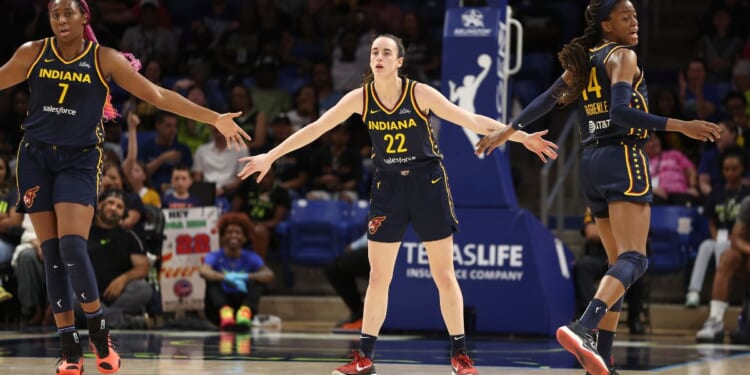 Caitlin Clark (#22) of the Indiana Fever celebrates a first-half three-pointer with Allya Boston (#7) and Tami Fagbenle (#14) while playing the Dallas Wings at College Park Center Friday in Arlington, Texas.