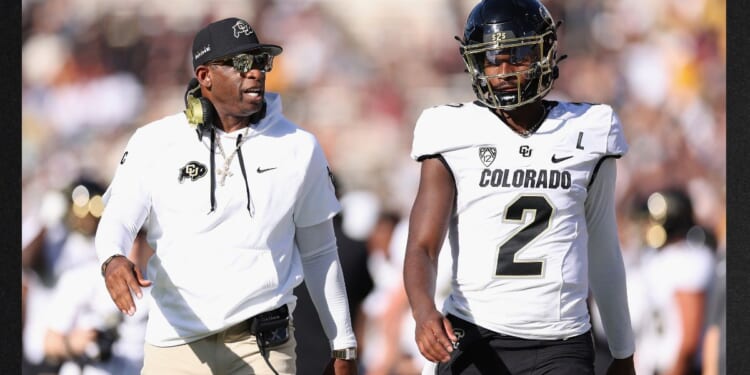 Head coach Deion Sanders of the Colorado Buffaloes talks with his son, quarterback Shedeur Sanders, during the NCAAF game against the Arizona State Sun Devils Oct. 7 in Tempe, Arizona.