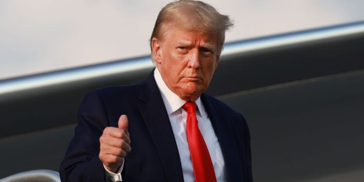 Former President Donald Trump gives a thumbs up as he arrives at Atlanta Hartsfield-Jackson International Airport in Atlanta on Aug. 24.