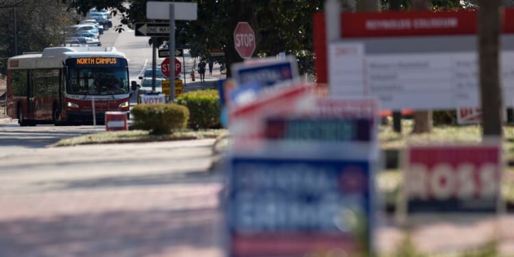 A bus moves near election signs at an election center on the campus of North Carolina State University in Raleigh on Feb. 22.