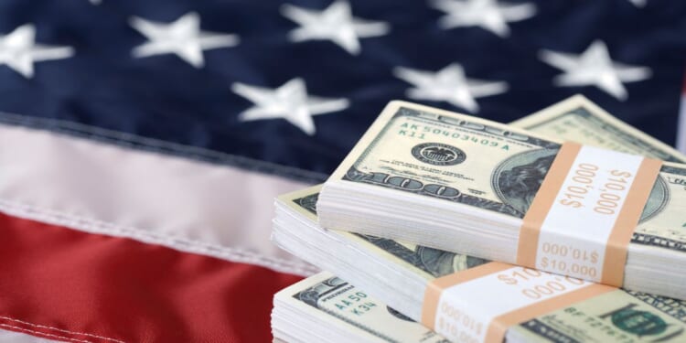 This Getty stock image shows a stack of cash on the U.S. flag.