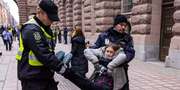 Greta Thunberg is arrested by police officers during a protest with "Reclaim The Future" outside of the Swedish parliament, Riksdag, on March 15, 2024 in Stockholm, Sweden.