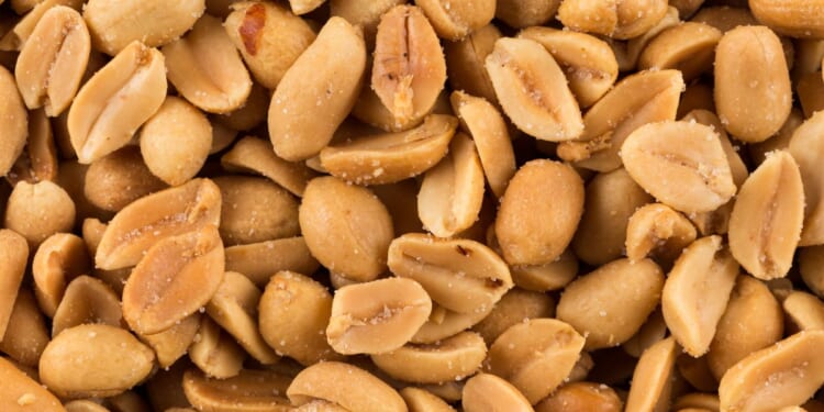 This stock image shows a close up of salted peanuts.