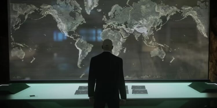 "Hitman" series protagonist Agent 47 looking at a map of the world.