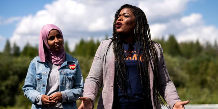 Rep. Ilhan Omar watches as Rep. Cori Bush speaks while visiting the headwaters of the Mississippi River where the Line 3 Pipeline is being constructed on September 4, 2021 in Park Rapids, Minnesota.