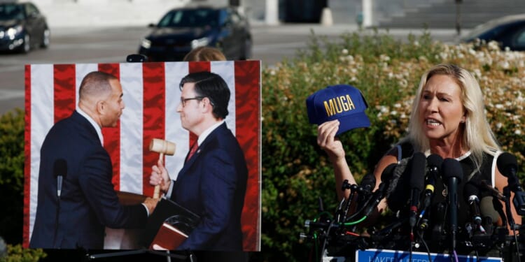 Rep. Marjorie Taylor Greene holds up a "Make Ukraine Great Again" hat while speaking from the steps of the U.S. Capitol in Washington, D.C., on Wednesday, announcing when she will call for the removal of Speaker of the House Mike Johnson.