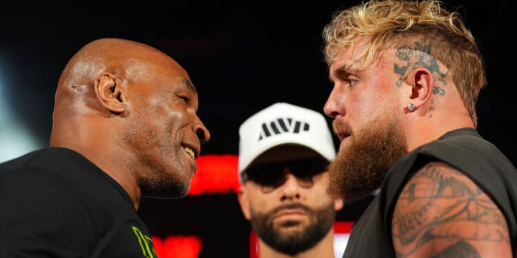 Mike Tyson, left, and Jake Paul pose onstage during a news conference at Texas Live! in Arlington, Texas, on May 16.