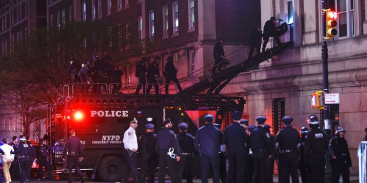 NYPD officers in riot gear enter Hamilton Hall at Columbia University, where pro-Palestinian students had barricaded set up an encampment, in New York City on Tuesday.