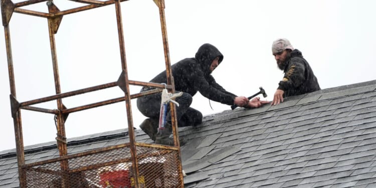 workers repairing a church roof