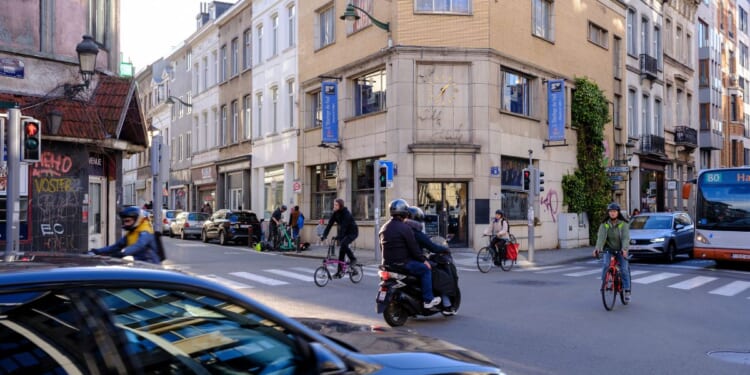 People cross at the intersection between the 'Rue du Trone' and the 'Chaussee de Wavre' on March 28, 2024 in Ixelles, Belgium.