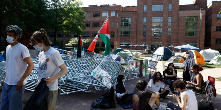 Pro-Palestinian protesters sit outside their tents in an encampment at University Yard at George Washington University in Washington, D.C., on Monday.