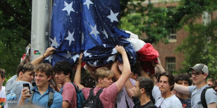 On Tuesday, a group of UNC student, identified as members of fraternities, stood together to hold up the American flag for an hour while anti-Israel protesters attempting to take down the flag and threw bottles, water, and rocks at them and hurled insults.