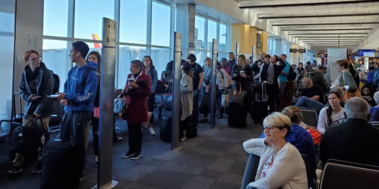 People line up based on boarding group numbers to board a Southwest Airlines flight at Oakland International Airport in California on Jan. 5, 2020.