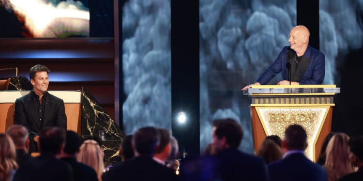 Tom Brady looks on while Jeff Ross speaks onstage during "The Greatest Roast of All Time" for Netflix at the Kia Forum in Inglewood, California, on Sunday.