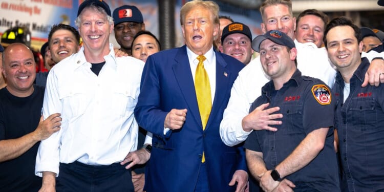 Former President Donald Trump poses for photos with members of the FDNY Engine 2, Battalion 8 firehouse on Thursday in New York City. Trump delivered pizza to a firehouse after a court appearance in his hush money trial.