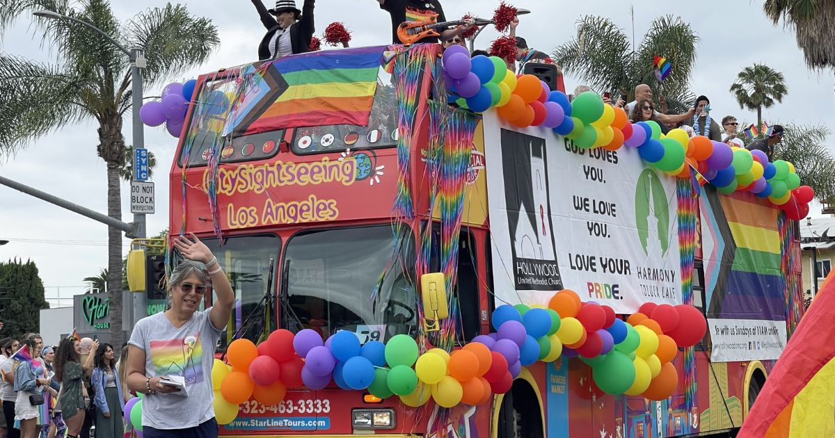 Members of the Hollywood United Methodist Church wave from a top a sightseeing bus decorated with rainbow-colored balloons and flags during the LA "Pride" Parade in Hollywood on June 11, 2023.