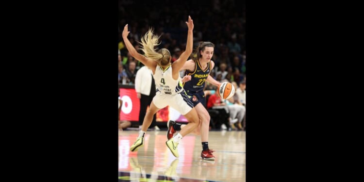 Caitlin Clark #22 of the Indiana Fever drives against Jacy Sheldon #4 of the Dallas Wings at College Park Center on May 3, 2024 in Arlington, Texas.