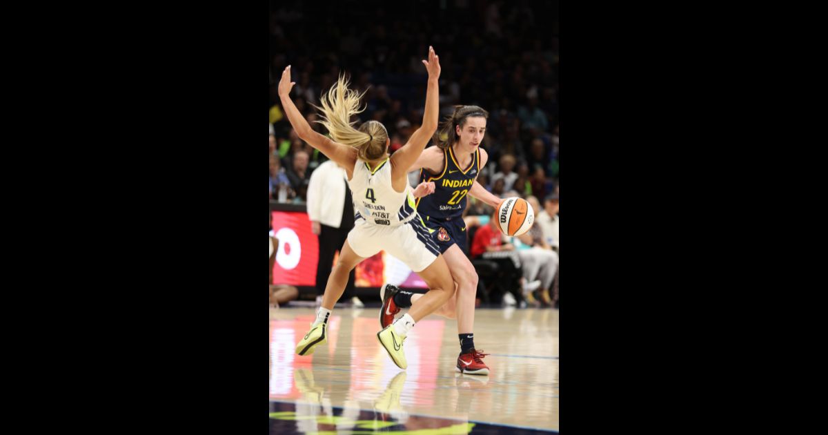 Caitlin Clark #22 of the Indiana Fever drives against Jacy Sheldon #4 of the Dallas Wings at College Park Center on May 3, 2024 in Arlington, Texas.