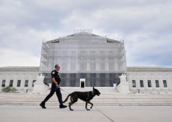 A Capitol Police officer walks a dog outside of the Supreme Court on Sept. 24, 2025, in Washington, DC.