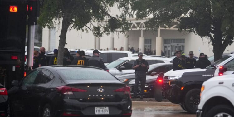 Law enforcement gather at a staging area close to a U.S. Immigration and Customs Enforcement office after a reported shooting, in Dallas, Texas, on Wednesday.