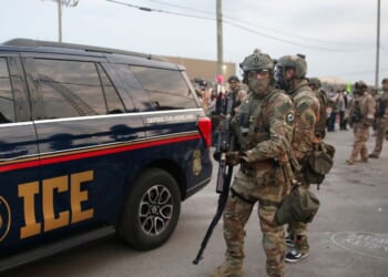 Immigration and Customs Enforcement agents armed with less-lethal weapons gather outside an ICE processing center during a protest in Broadview, Illinois, on Sept. 19, 2025.