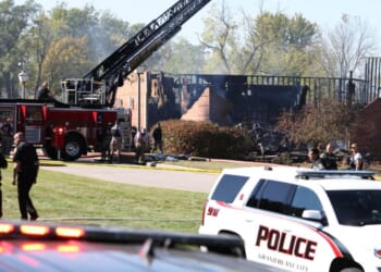 Fire and law enforcement officers stand outside the Church of Jesus Christ of Latter-day Saints in Grand Blanc Township, Michigan, following a shooting and fire on Sunday.