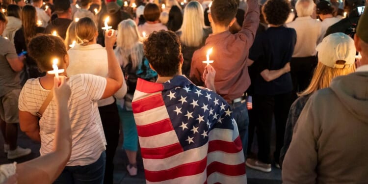 An attendee wears a U.S. flag during a candlelight vigil for Turning Point USA founder Charlie Kirk on Sept. 10, 2025, in Seattle, Washington.