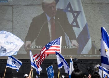 People watch President Donald Trump address the Knesset, Israel's parliament, on a giant screen in Hostages Square in Tel Aviv, Israel, on Monday.