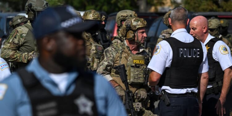 Chicago police officers speak with federal agents in Chicago, Illinois, on Oct. 4, 2025.
