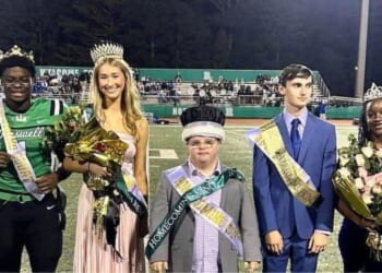 Trey Smith, left, star quarterback at Roswell High School in Roswell, Georgia, gave his homecoming king crown to Jake Jeffries, center, described as "a devoted senior with Down syndrome who is the team’s biggest fan and longtime helper with the training staff."