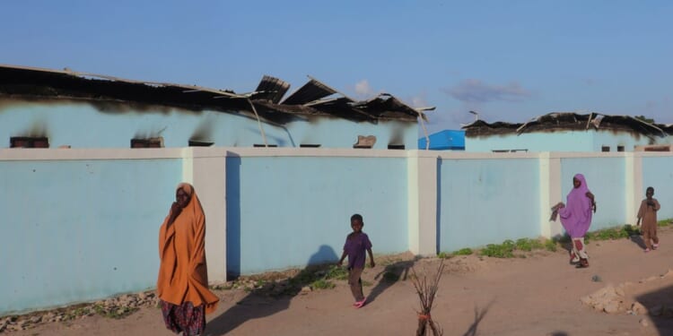 People walk past torched houses following an attack by Boko Haram in Darul Jamal, Nigeria, on Sept. 6.