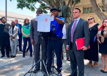 Jonathan Wright, 39, holds up the T-shirt he was given when he first went to MacLaren Children's Center in El Monte as an 8-year-old during a news conference in Los Angeles on June 9, 2022.
