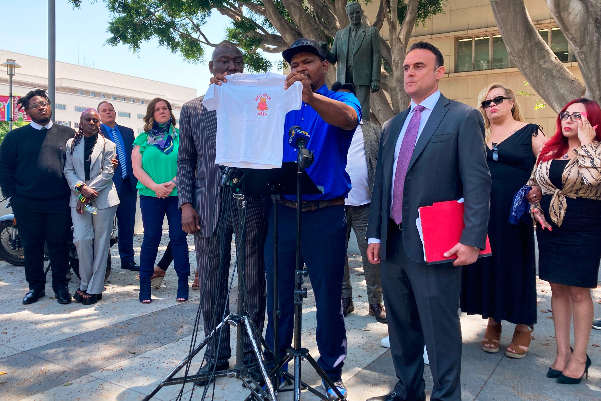 Jonathan Wright, 39, holds up the T-shirt he was given when he first went to MacLaren Children's Center in El Monte as an 8-year-old during a news conference in Los Angeles on June 9, 2022.