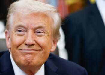 President Donald Trump smiles listening to speakers in the Oval Office of the White House in Washington, DC on Oct. 16, 2025.