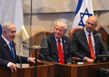 Prime Minister of Israel Benjamin Netanyahu speaks next to President Donald Trump and other politicians at Israel's parliament on Oct. 13, 2025.