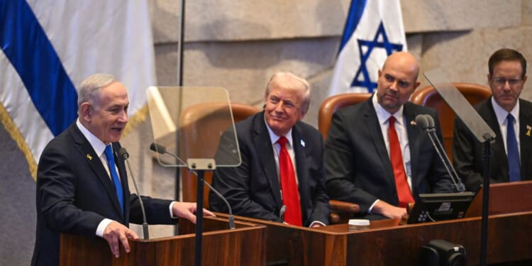 Prime Minister of Israel Benjamin Netanyahu speaks next to President Donald Trump and other politicians at Israel's parliament on Oct. 13, 2025.