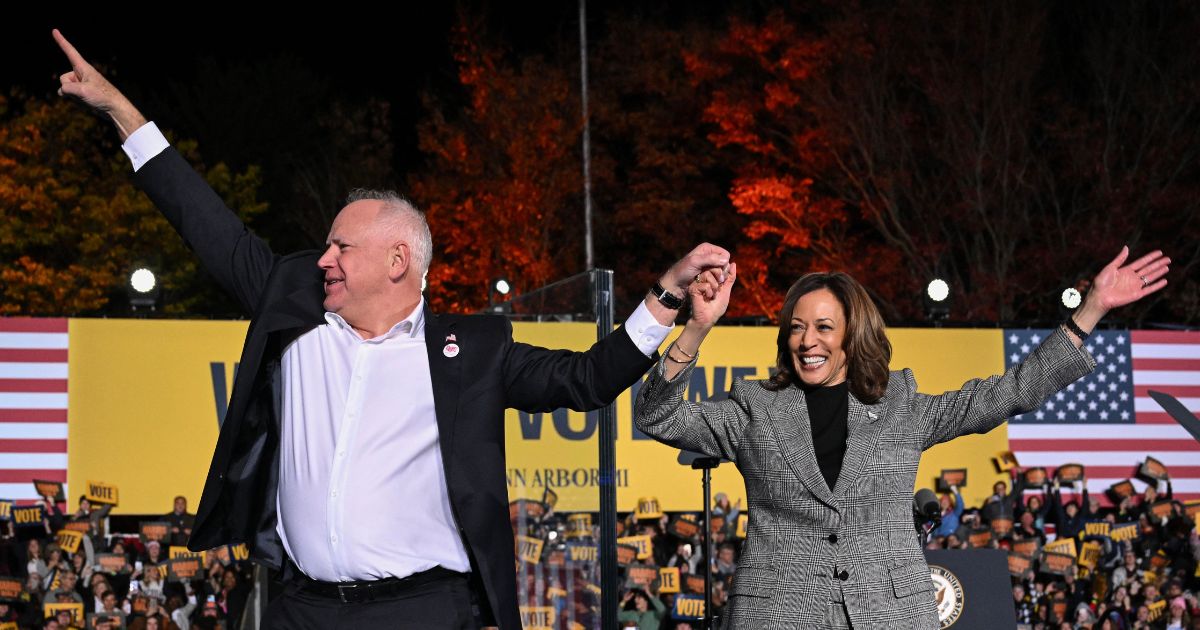 Vice President and Democratic presidential candidate Kamala Harris, right, and her vice presidential running mate Minnesota Gov. Tim Walz greet supporters during a campaign rally in Ann Arbor, Michigan, Oct. 28, 2024.