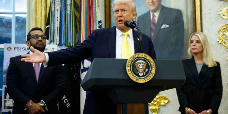 President Donald Trump, center, speaks to reporters during a news conference in the Oval Office of the White House in Washington, D.C., on Wednesday.
