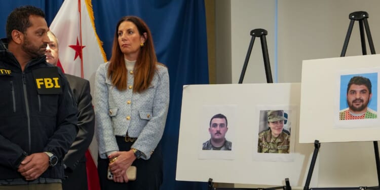 FBI Director Kash Patel looks at photographs of the two National Guard soldiers shot on Wednesday along with a photograph of their alleged assailant in Washington, DC on Nov. 27, 2025.
