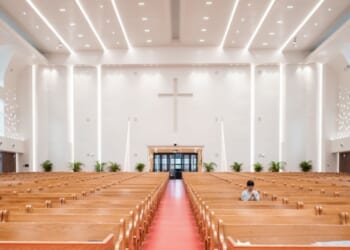 A woman prays inside a church.