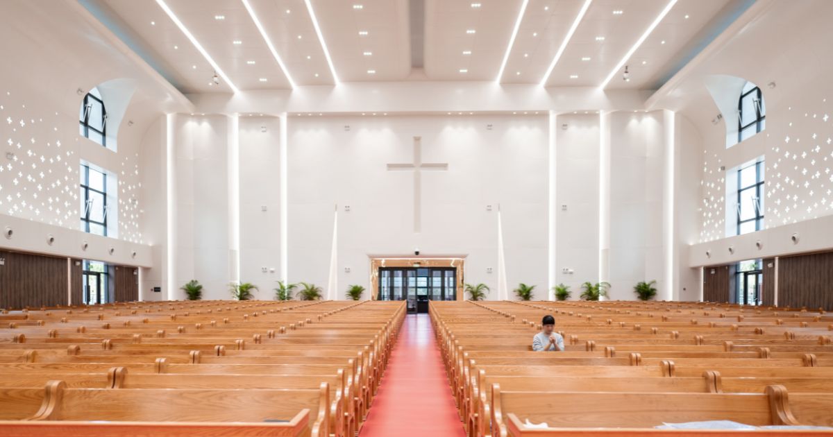A woman prays inside a church.