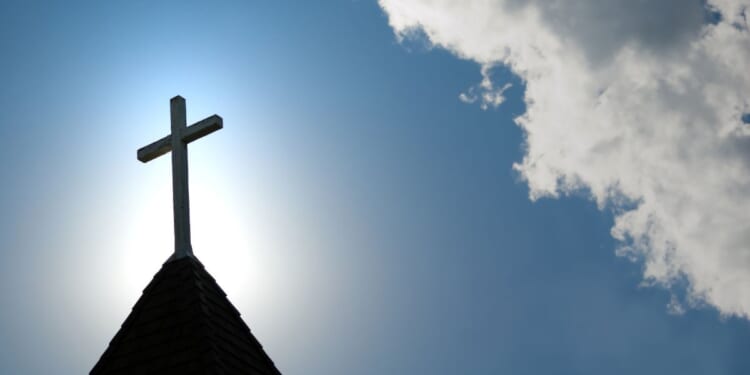 A wooden cross sits on top of a church building.