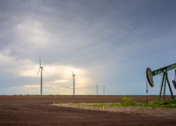 An oil pumpjack is seen near a field of wind turbines on Oct. 4, 2023, in Nolan, Texas.